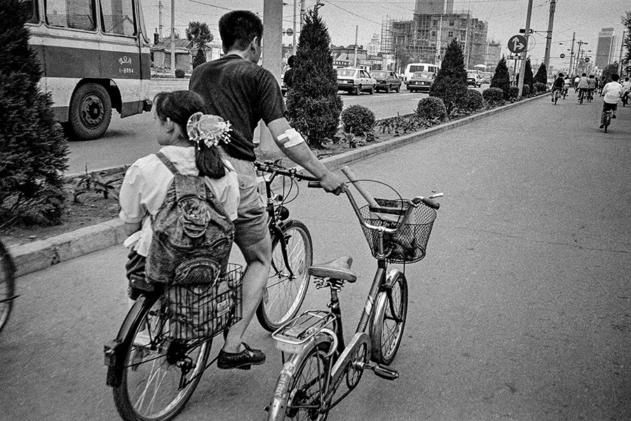 1991年8月《放学路上》，辽宁省沈阳市北陵大街，打工受伤的父亲依然每天准时接女儿送放学回家。.jpg