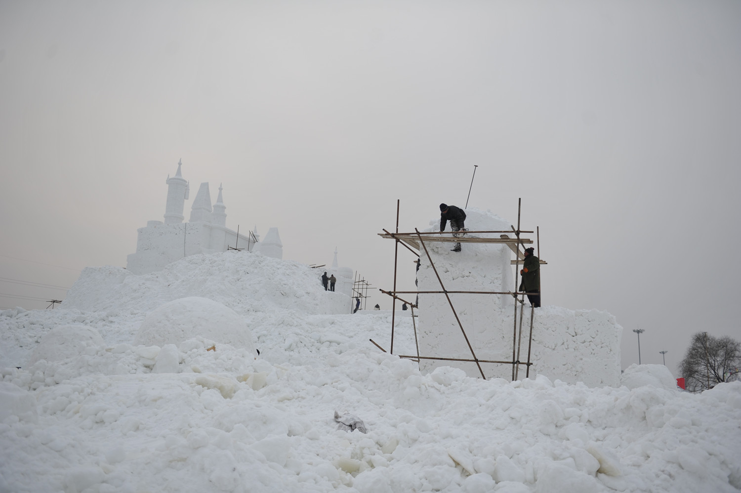 2012年1月《冰雪世界》，辽宁省沈阳市，雕塑工人正在制作供游客参观的雪雕，政府计划将冬季的棋盘山风景区打造成冰雪大世界。谢军摄影.JPG